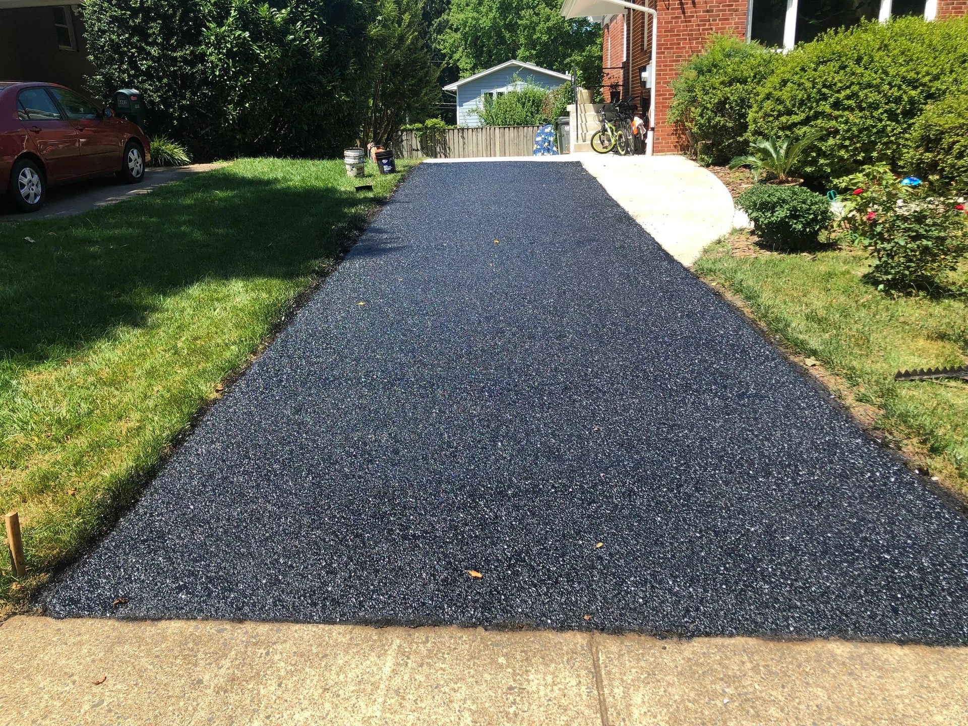 Newly paved residential driveway beside a landscaped home