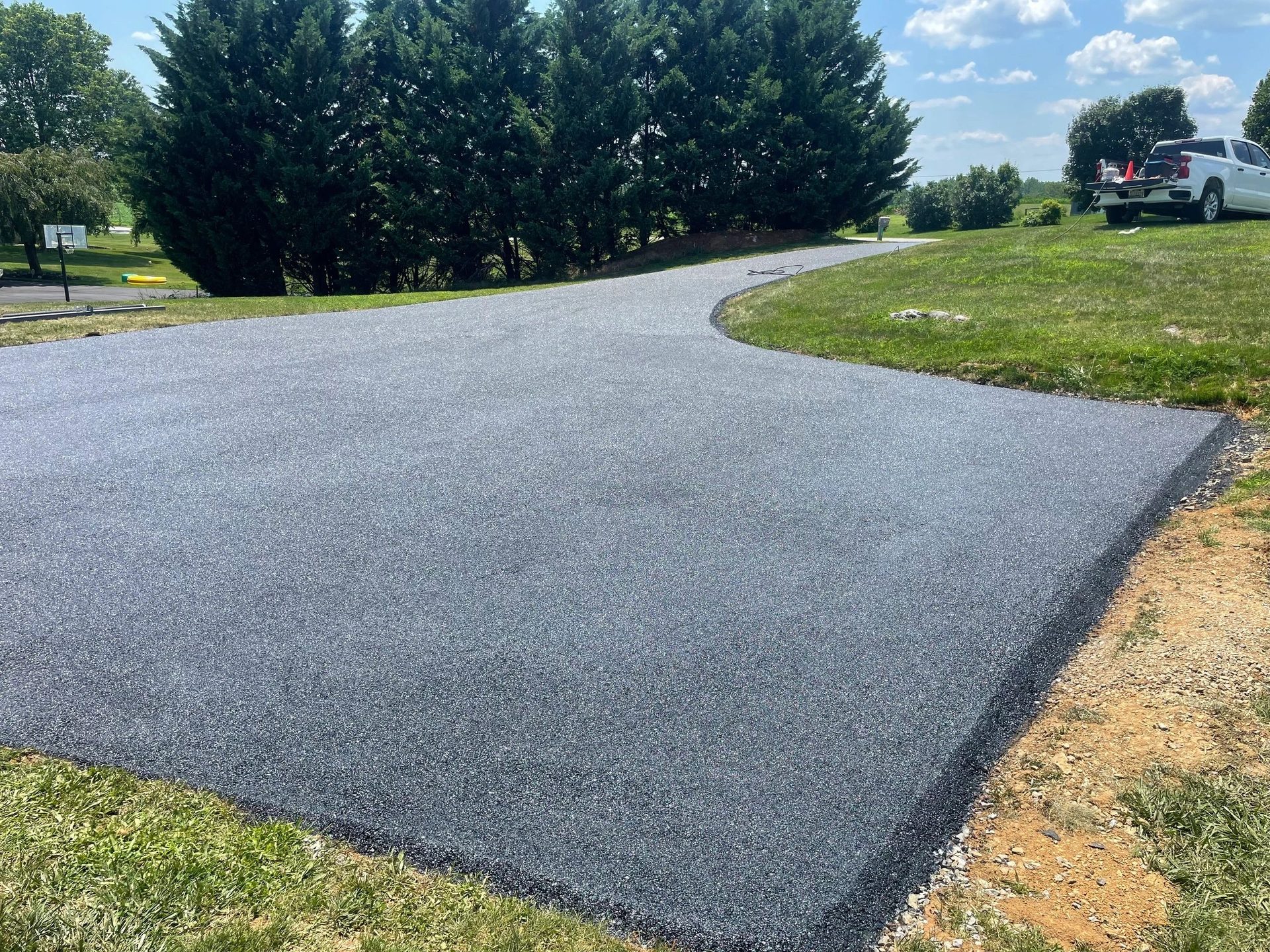 Fresh asphalt paving on a wide residential driveway
